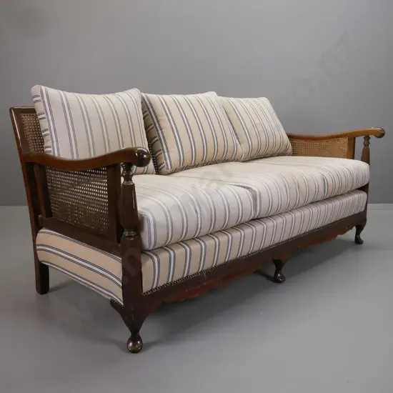 mid-century mahogany cab-leg bergere cane settee with shaped crest to back, fluted arm supports, striped fabric squabs -