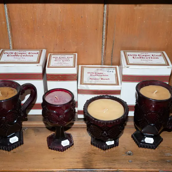 assorted candles and ruby glass vessels