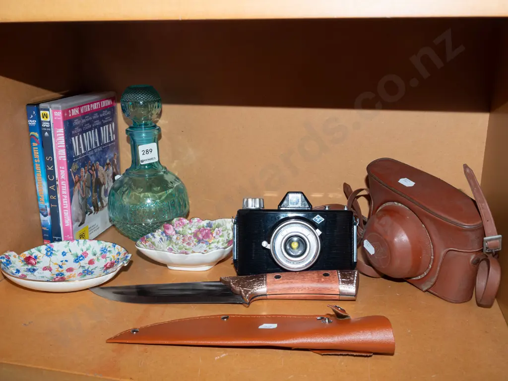 shelf; floral dishes, DVDs, decanter, film camera, knife with sheath Image 1++