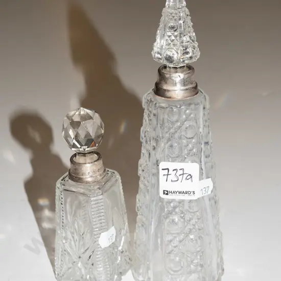 2x cut glass stoppered bottles - both have sterling silver rims - 1 stopper is mismatched to bottle, other has chips