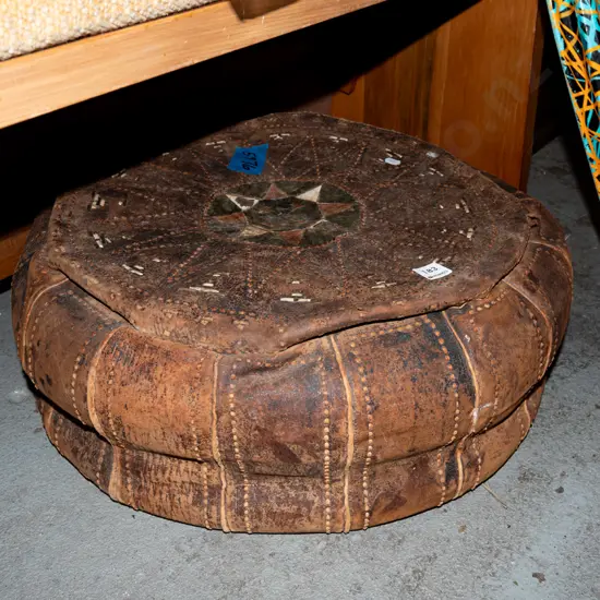 hand worked; leather pouffe - rips and wear