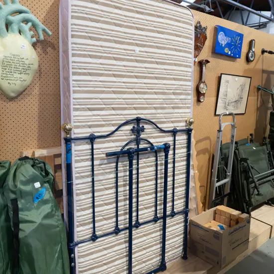 single slat bed base and mattress with blue metal and brass ends