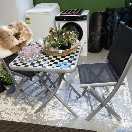 black and white checked glass top outdoor table with 2 chairs