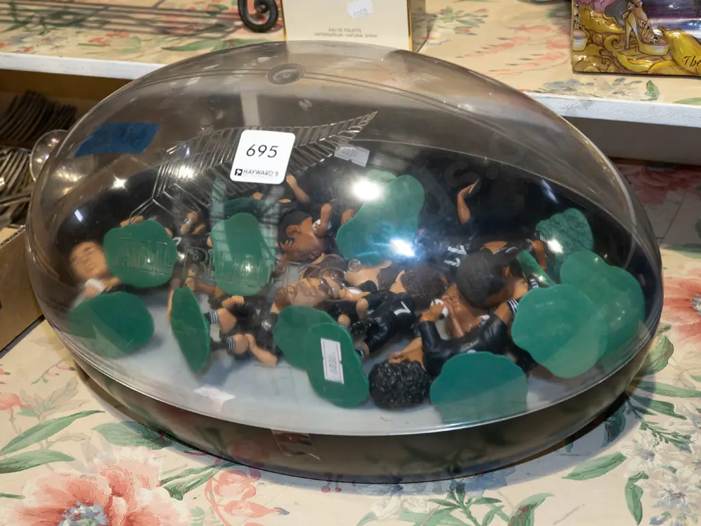 All Blacks rugby ball shaped case and various plastic All Black figurines Image 1++