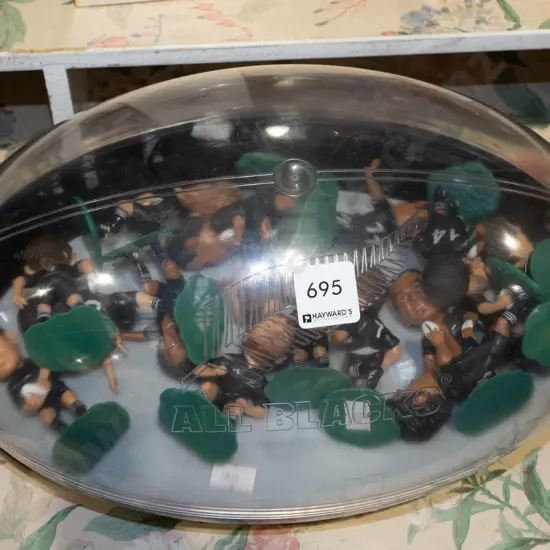 All Blacks rugby ball shaped case and various plastic All Black figurines