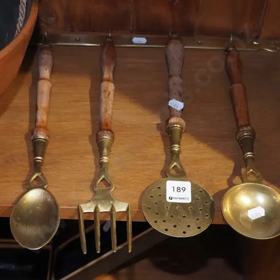 wood and brass cooking utensils with brass rack