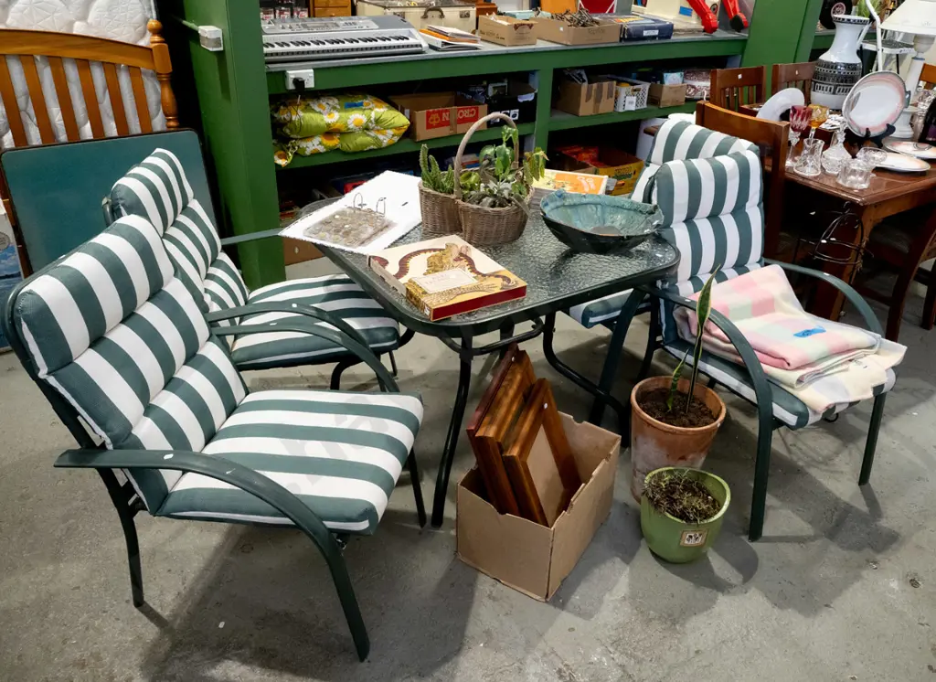 glass top outdoor table with 4 matching chairs and green striped cushions Image 1++
