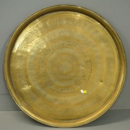 large brass tray with pressed & incised designs - some dents. Diameter 600