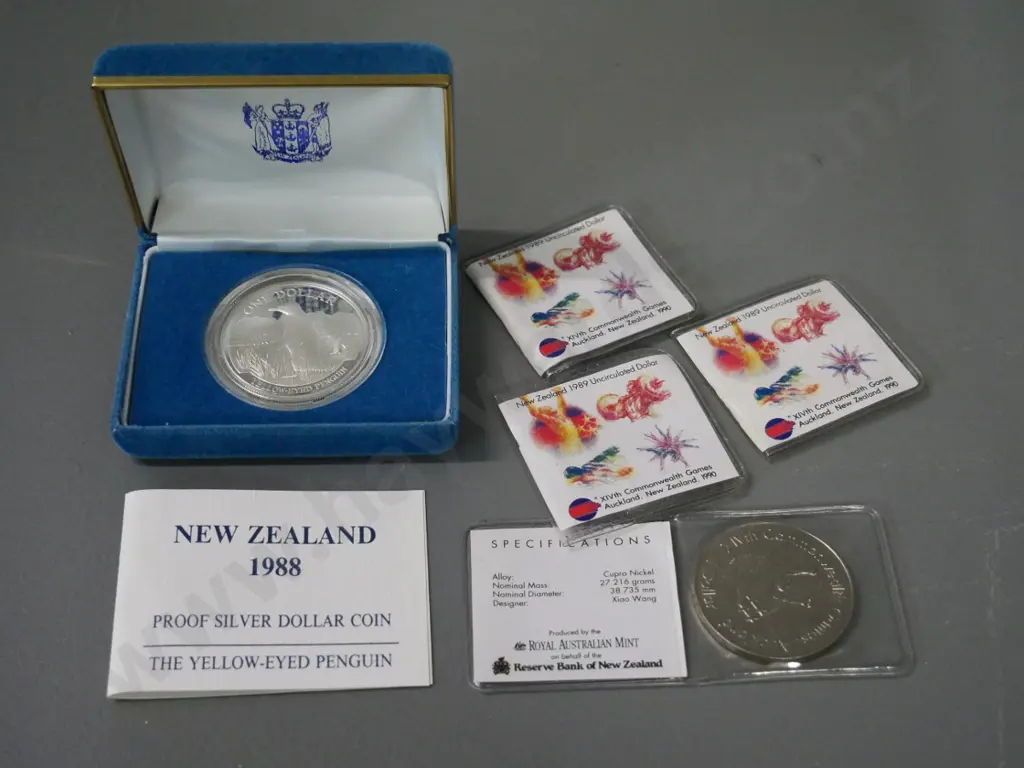 5 New Zealand coins - cased 1988 Yellow Eyed Penguin silver dollar and 4 1989 Commonwealth Games dollars in plastic Image 1++