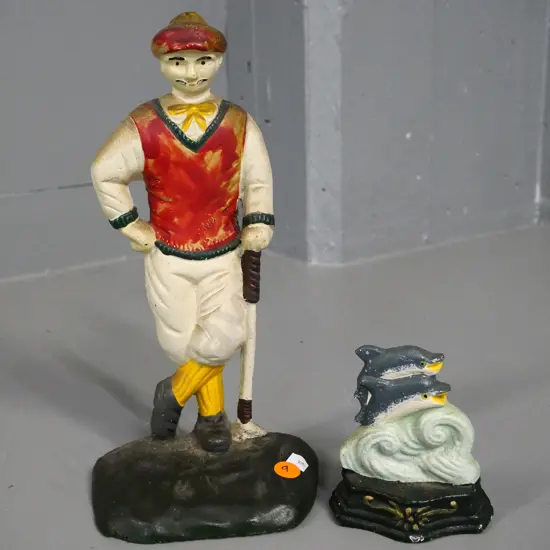 2 painted cast iron door stops - golfer H-260 and a small one with 2 leaping dolphins