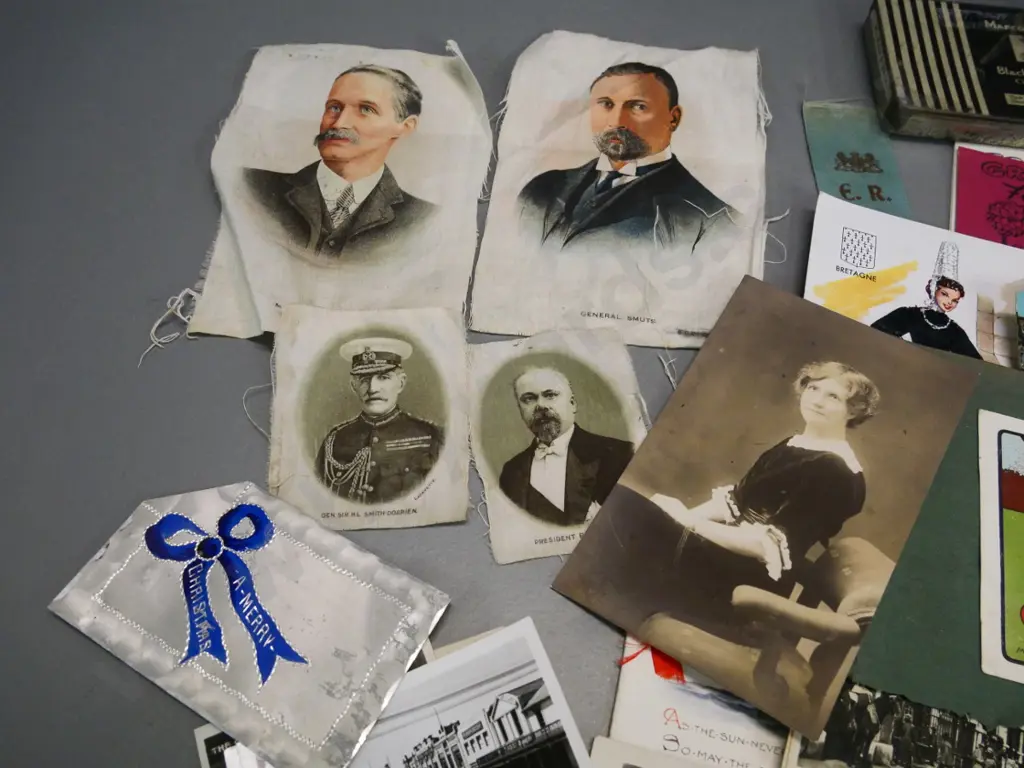 collection of photos, tins, greeting cards, portraits printed on fabric, early NZ postcards on torn album sheets etc. Image 1++