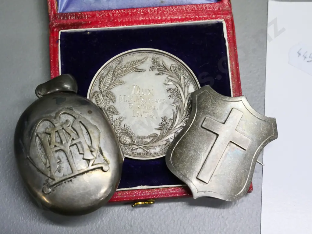 cased 1874 Otago Girls' High SchoolDux medal - M.S. Maitland, unmarked locket w/2 photos & a cross & shield brooch Image 1++