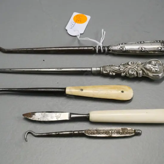 2 sterling silver handled button hooks, 2 other button hooks and a a bone-handled manicure item