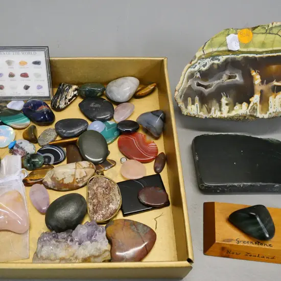 collection of gemstones - some are polished, several cut small stones, and a small Gemstones of the World sample set
