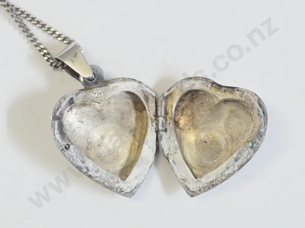silver heart shaped locket has flower engraving on front stamped 925 Image 1++