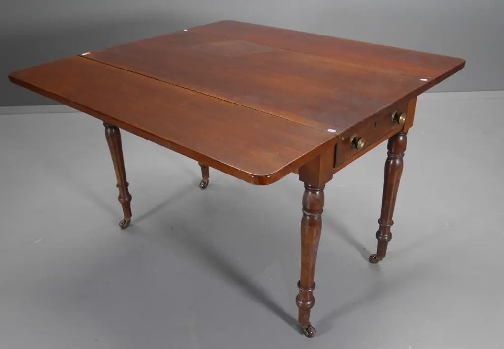 mahogany drop-side supper table w/drawer, turned legs on porcelain casters, some fading/marks H685 W1060 L985 open Image 1++
