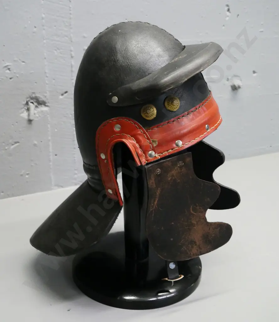 reproduction Roman leather helmet with brass studs and a wooden stand Image 1++