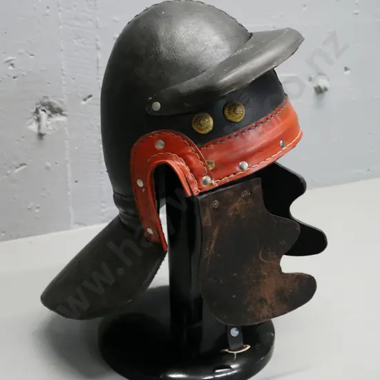 reproduction Roman leather helmet with brass studs and a wooden stand