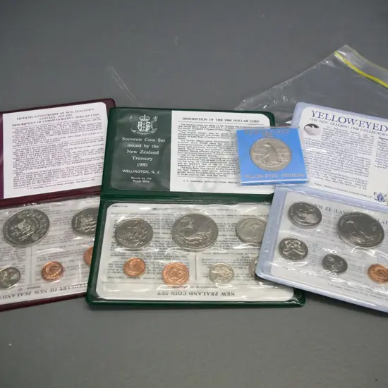 3 New Zealand cased collector coin sets - 1980, 1983, 1988 - and a Yellow Eyed Penguin dollar