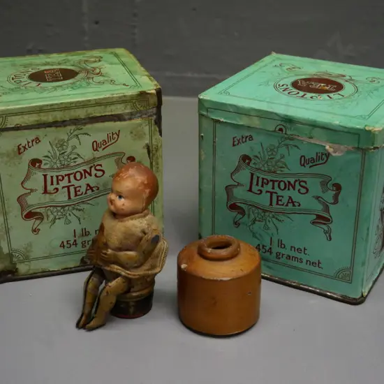 small German mechanical toy with celluloid head, no key, 2 Lipton's tea tins, 1 has contents, stoneware ink bottle