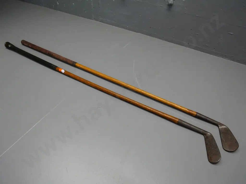 2 vintage golf clubs with wooden stems and leather grips Image 1++