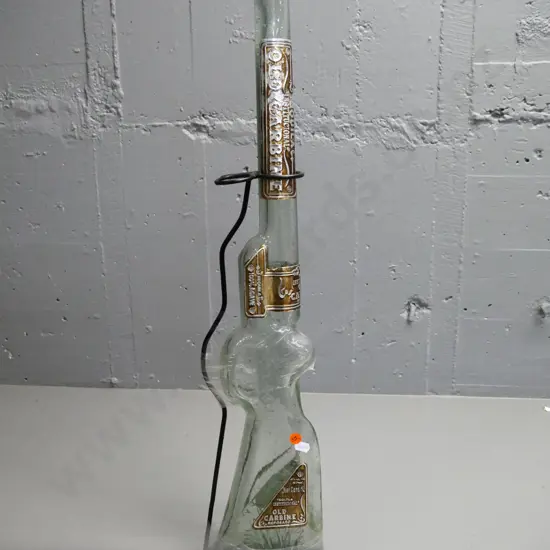 tall rifle-shaped Old Carbine tequila bottle (empty) in metal stand - some wear to metal labels. H-630