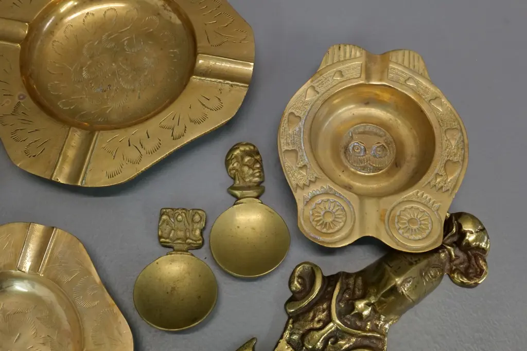 assorted brass items - etched ashtrays, heavy letter opener, 2 tea scoops - & a plated mother of pearl butter knife Image 1++