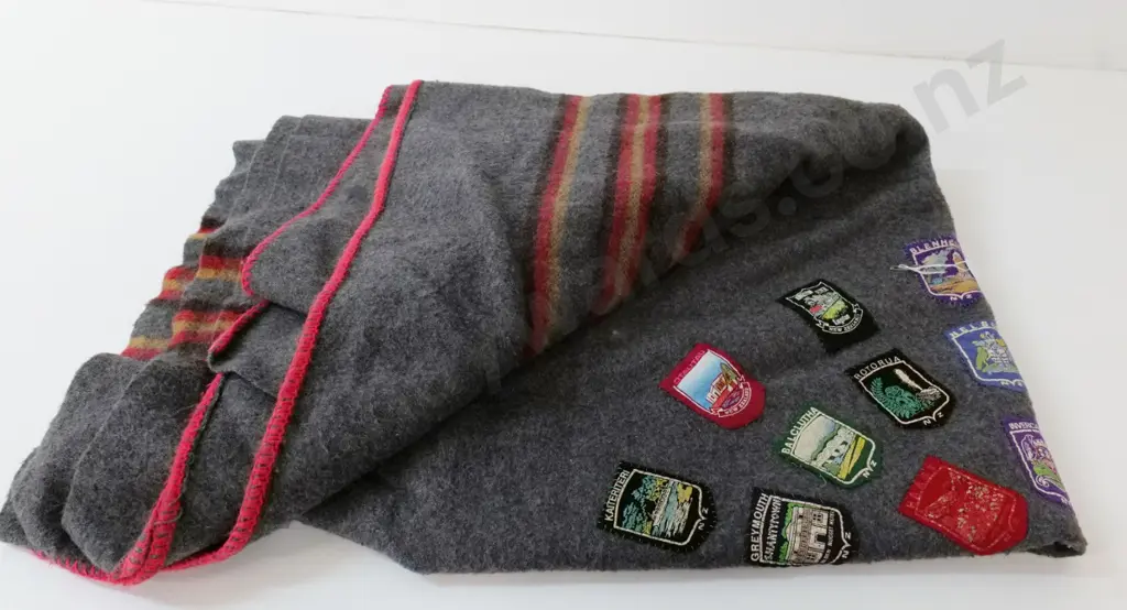 grey woollen blanket with approx. 30 assorted New Zealand place names badges Image 1++