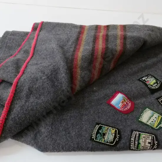 grey woollen blanket with approx. 30 assorted New Zealand place names badges