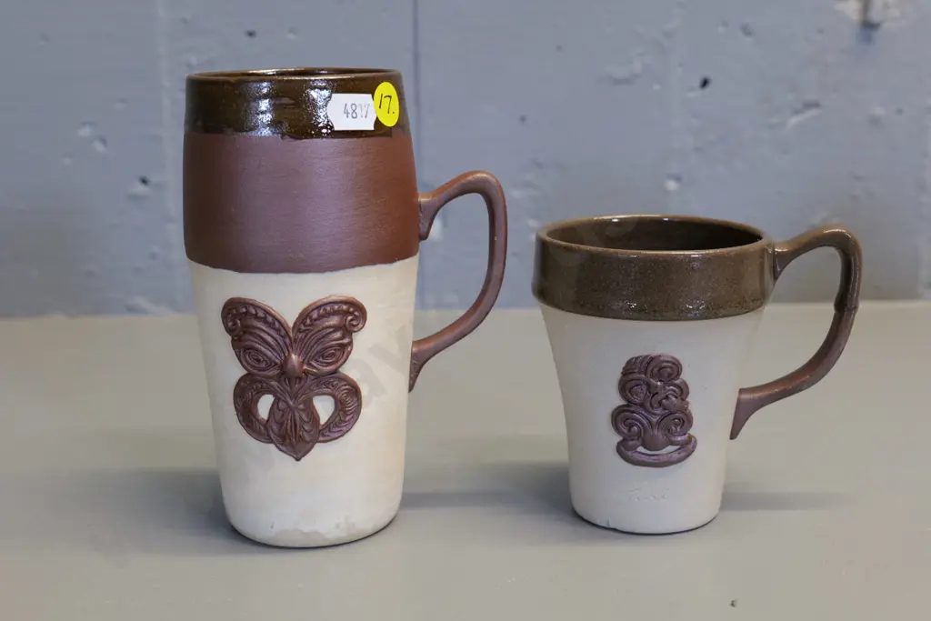 Temuka pottery - 2 cream brown glaze Maori tiki motif mugs, short one marked Jasper Lovatt 1960, has tiny fleck Image 1++