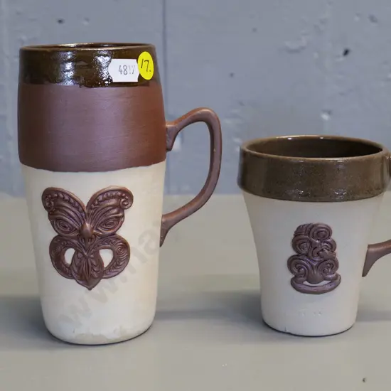 Temuka pottery - 2 cream brown glaze Maori tiki motif mugs, short one marked Jasper Lovatt 1960, has tiny fleck