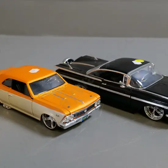 2 die-cast model cars - 1:24 Jada black Chevy Impala and 1:24 Maisto orange Chevy Chevelle