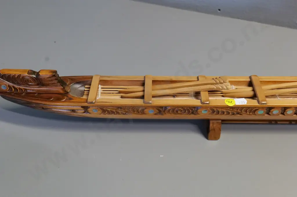 hand carved wooden waka model on wooden stand, with paddles, paua insets - has 'Te Aroha' sticker H280 L840 Image 1++