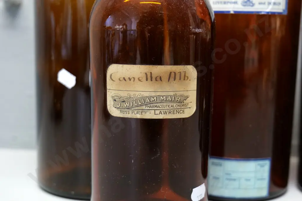 5 brown glass apothecary bottles, one with non-matching stopper, taller H370, smaller one with Lawrence NZ label Image 1++