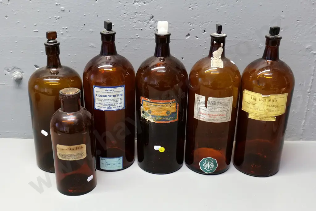 5 brown glass apothecary bottles, one with non-matching stopper, taller H370, smaller one with Lawrence NZ label Image 1++