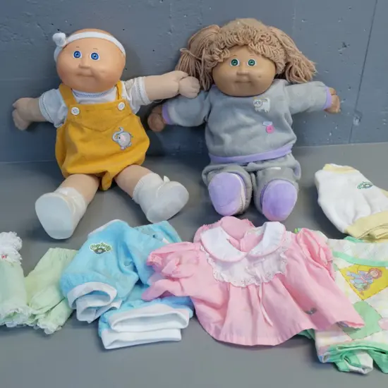 two Cabbage Patch Kids dolls and assorted clothing - dolls H-450