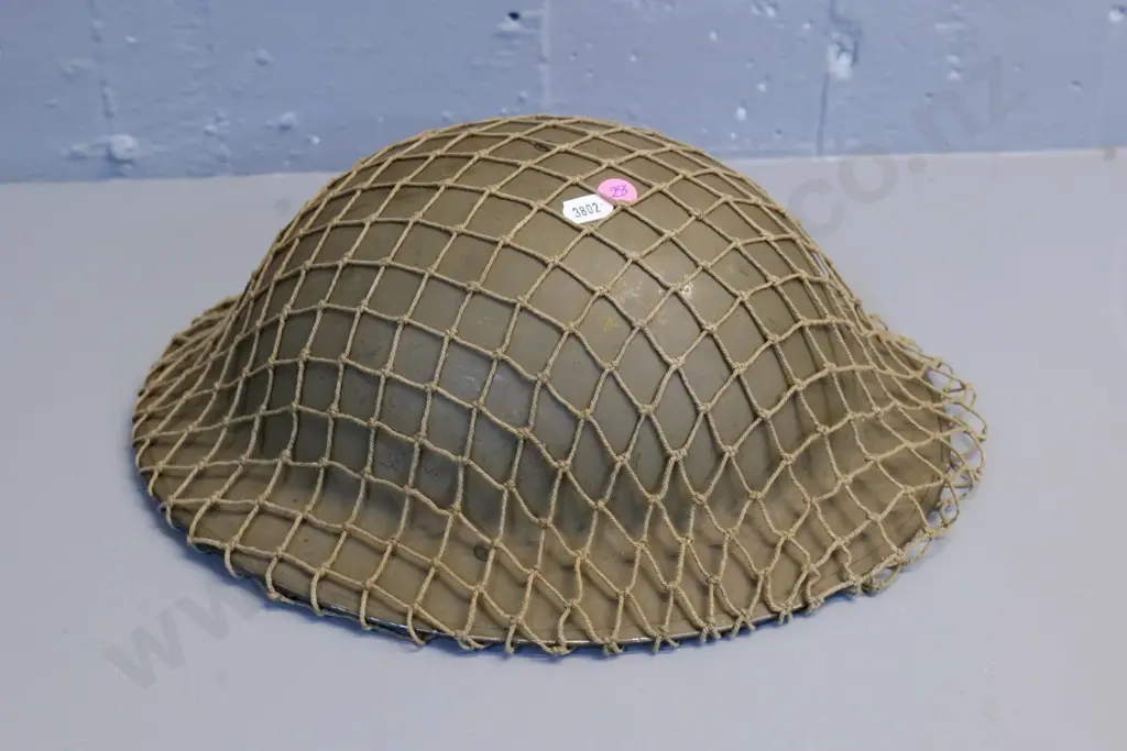 metal WWII era military helmet with leather fittings, netting cover Image 1++