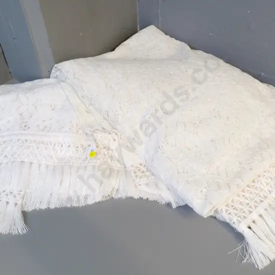 pair of single bed throws with traditional lace and fringed edges - one is a darker cream colour