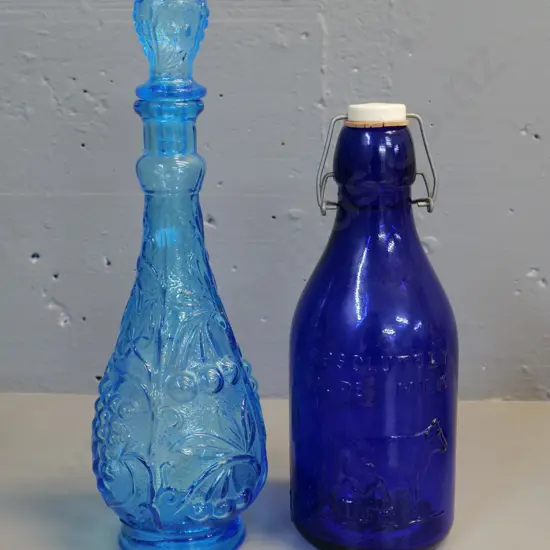 blue stoppered genie bottle H350 (no stopper liner) and a reproduction 1 quart cobalt blue milk bottle (Made in Italy)