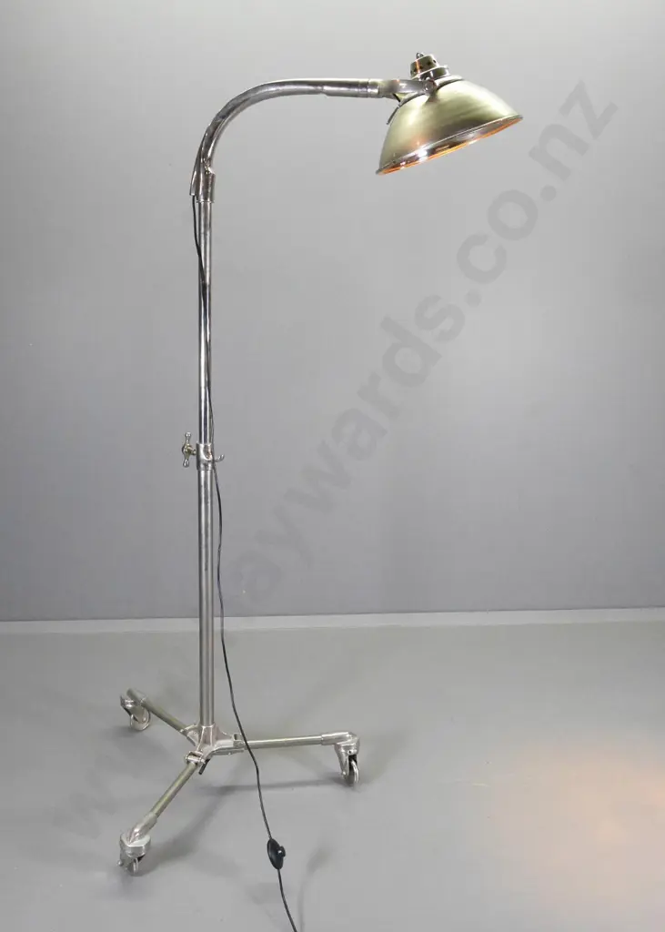 industrial style floor lamp on heavy metal casters with tilting head, some pitting to metal H1420 W1000 Image 1++