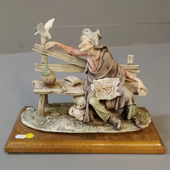 composite figurine on wooden base - man feeding pigeon - marked G. Armani H200 L260