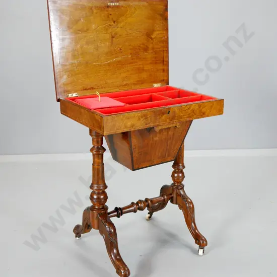 Victorian sewing table with burr veneer top (w/split), carved base, porcelain casters, restored satin interior H700