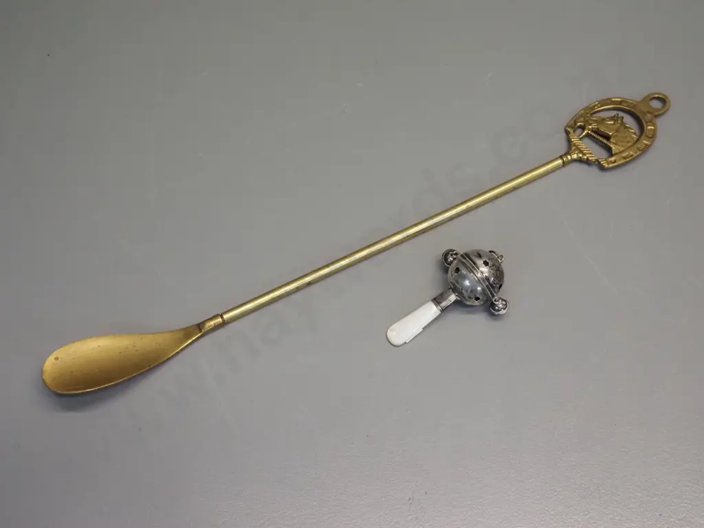 long handled brass shoe horn with horse motif L-500 and a silver (unmarked) baby's rattle with mother of pearl handle Image 1++