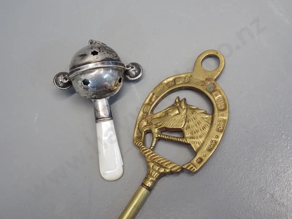 long handled brass shoe horn with horse motif L-500 and a silver (unmarked) baby's rattle with mother of pearl handle Image 1++